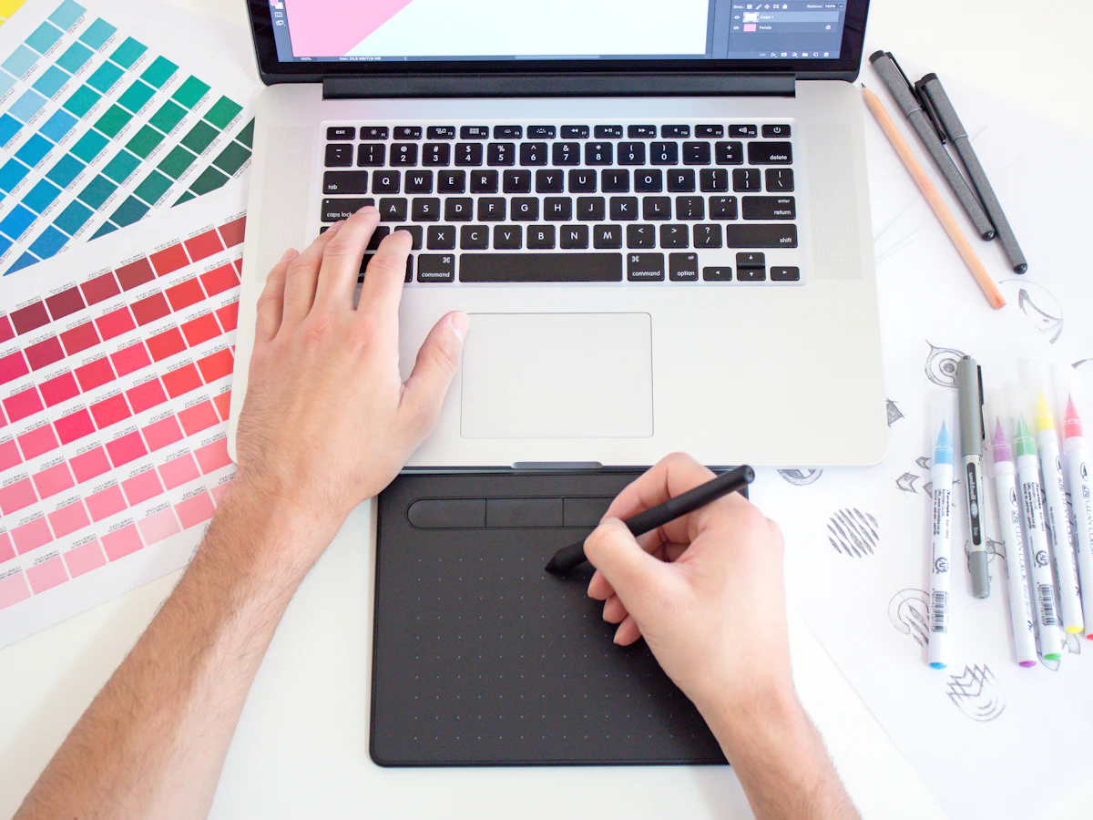 Designer drawing on a graphics tablet next to colour swatches