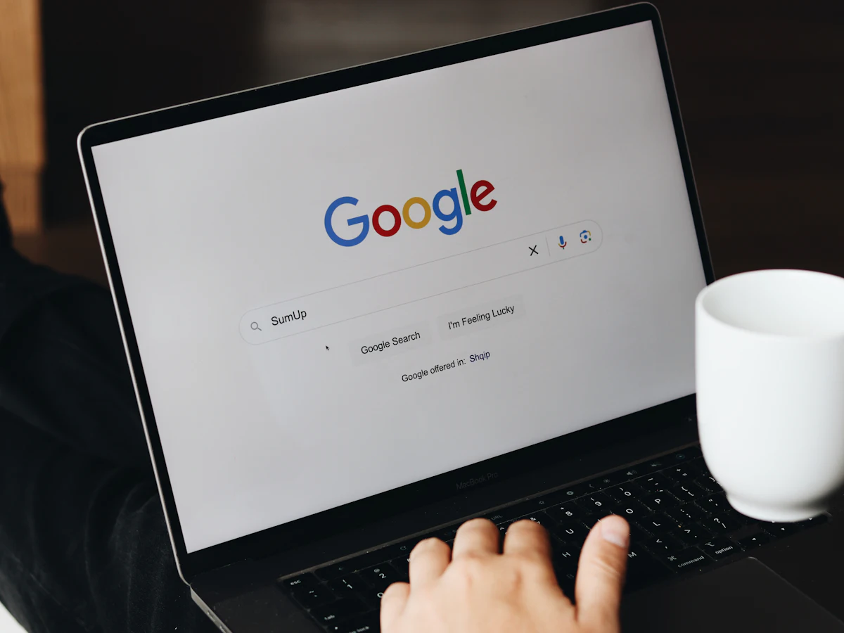 Person typing a Google search on a laptop