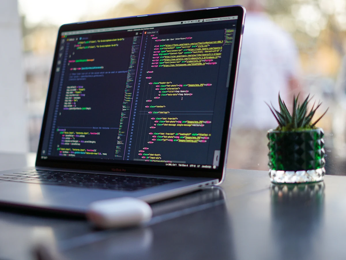 Laptop showing website code on a desk